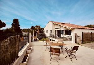 a patio with a table and chairs and a house at Duplex vue mer plage de Saint-Clair in Le Lavandou