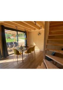 ein Esszimmer mit einem Tisch, Stühlen und einem Fenster in der Unterkunft La Cabane du Petit Moulin in Bressuire