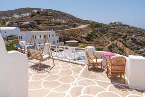 a balcony with chairs and a view of a hill at Antiparos in Síkinos