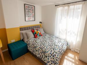 1 dormitorio con cama con reposapiés azul y ventana en Pass the Keys Modern Stylish apartment with parking, en Bournemouth
