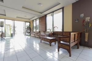 a living room with chairs and tables and windows at RedDoorz Plus near Museum Angkut Batu 4 in Batu