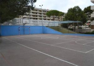 um campo de ténis com uma rede e um cesto de basquetebol em Brisa Mar Apartamentos em Salou