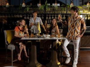 a group of people sitting around a table in a bar at SKYVIEW Hotel Bangkok - Sukhumvit in Bangkok