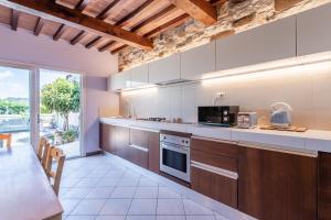 a large kitchen with wooden cabinets and a large window at Villetta Tiziana in Pisa