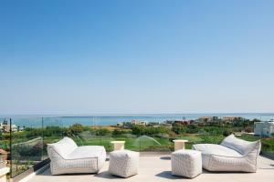 un grupo de sillas blancas sentadas en la parte superior de un edificio en Skianos Villa, en La Canea 43 fotos más