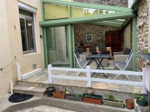 een patio met stoelen en een tafel op een veranda bij "La Marinière" - Charmante maison familiale au cœur de la ville in Granville