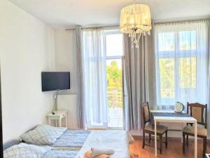 a bedroom with a bed and a table and a dining room at Viator in Ustka