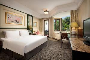 um quarto com uma cama, uma secretária e uma televisão em Seaview Resort Xiamen em Xiamen