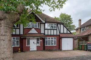 a detached house with a garage in front of it at Flexistay Aparthotel Sutton in Sutton
