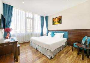 a hotel room with a bed and a table at Yuni Hotel And Apartment in Da Nang