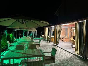 un patio con tavoli, sedie e ombrelloni di notte di Pesvebi Design Hotel and Cellar a Borjomi