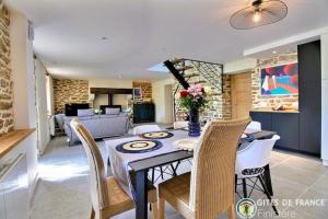 a dining room and living room with a table and chairs at Le Penty du Petit-Kerauret in Concarneau +71 photos