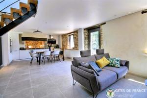 a living room with a couch and a kitchen at Le Penty du Petit-Kerauret in Concarneau
