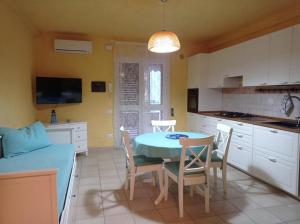 cocina y comedor con mesa y sillas en Case Vacanza Villaggio Riva Azzurra, en Policoro