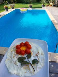 Un plato de comida en una mesa junto a una piscina. en Villa D Blagaj, en Blagaj
