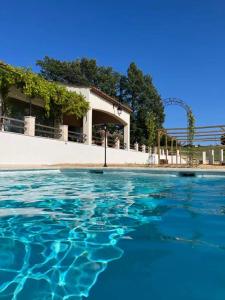 una piscina d'acqua di fronte a un edificio di Charmante maison avec piscine ad Artignosc-sur-Verdon