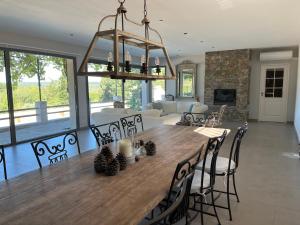 a dining room and living room with a table and chairs at Charmante maison avec piscine in Artignosc-sur-Verdon