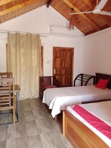 Habitación con 2 camas, mesa y escritorio. en Home Stay Resort en Nilaveli