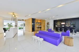 a living room with a purple couch and chairs at Mon Repos Hotel in Ayia Napa