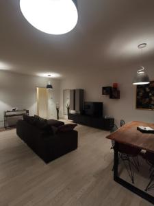 sala de estar con sofá negro y mesa en La casa di Greta, en Monza