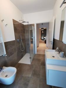 a bathroom with a shower and a toilet and a sink at La casa di Greta in Monza