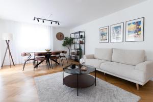 a living room with a couch and a table at Central Serviced Apartment in Engelberg