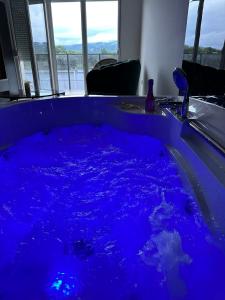 una bañera azul llena de agua azul en una habitación en Romantika 2, en Ostrovo