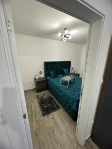 a bedroom with a blue bed and a mirror at Romantika 2 in Ostrovo