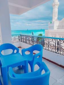 twee blauwe stoelen op een balkon met uitzicht op de oceaan bij مرسى مطروح in Marsa Matruh