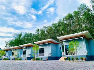 a row of buildings with trees in the background at Suanvadee Resort สวนวดี รีสอร์ท in Don Sak