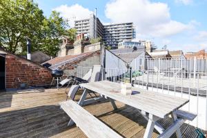 a wooden table on the roof of a building at The Hampstead Heath Escape - Trendy 1BDR Flat with Balcony in London