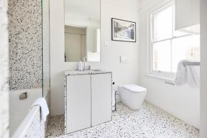 a white bathroom with a toilet and a sink at The Hampstead Heath Escape - Trendy 1BDR Flat with Balcony in London