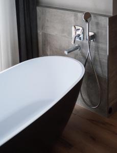 普豐德斯的住宿－Chalet Pfunds，浴室设有带淋浴喷头的浴缸。