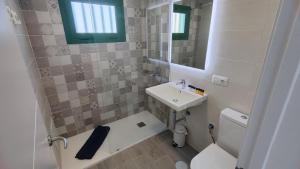bagno con lavandino, servizi igienici e specchio di Apartamento Julia Puerto del Carmen a Puerto del Carmen