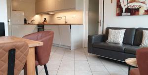 eine Küche und ein Wohnzimmer mit einem Sofa und einem Tisch in der Unterkunft It Winkelhûs in Terschelling