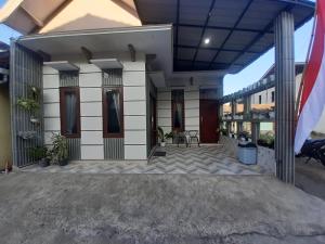 a building with a patio with chairs and a flag at Widodaren Homestay in Probolinggo