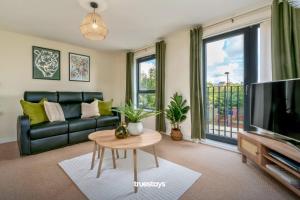 ein Wohnzimmer mit einem Sofa, einem TV und einem Tisch in der Unterkunft NEW Greydawn House - Stunning 4 Bedroom House in Stoke-on-Trent in Stoke on Trent