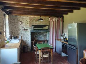 a kitchen with a table and a refrigerator at Le Bouchat : Maisonnette au calme pour 2 +1 guest 