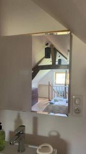 a mirror above a sink in a bathroom at Le Bouchat : Maisonnette au calme pour 2 +1 guest 