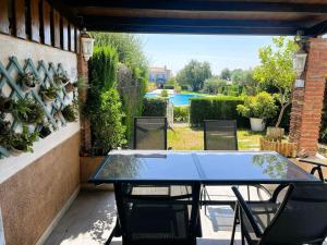 a table and chairs on a patio with a view of a pool at Villa Conchi in Les tres Cales
