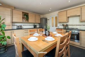 a large kitchen with a wooden table and chairs at NEW Greydawn House - Stunning 4 Bedroom House in Stoke-on-Trent in Stoke on Trent