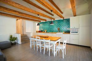 a kitchen with a wooden table and white cabinets at Matyodesign Vendégház in Tard