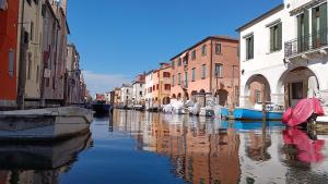 einen Kanal in einer Stadt mit Gebäuden und Booten in der Unterkunft Casa Cuccagna Chioggia - Vista Canal Vena in Chioggia