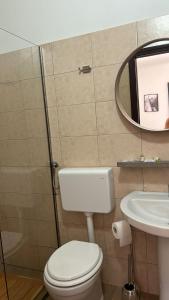 y baño con aseo, lavabo y espejo. en Ristorante Bar Fittacamere Le BISTROT, en Sonnino
