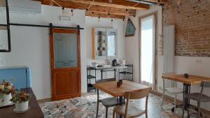 una habitación con 2 mesas y sillas y una puerta en Casa Cuccagna Chioggia - Vista Canal Vena, en Chioggia