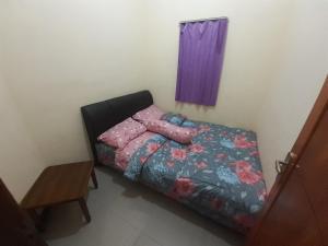a small bedroom with a bed with a colorful comforter at Widodaren Homestay in Probolinggo