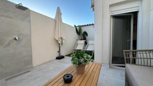 a patio with a table with a plant and an umbrella at Huellas de la Mancha in Burguillos de Toledo