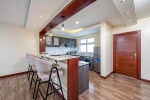 a kitchen with a bar with stools at Roma Court Serviced Apartments in Nairobi