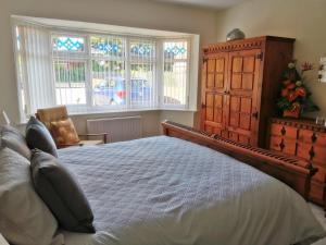a bedroom with a bed and a dresser and windows at Leylands 