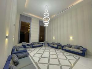 a lobby with blue couches and a checkerboard floor at فندق بلينسية Balensia Hotel in Al Madinah